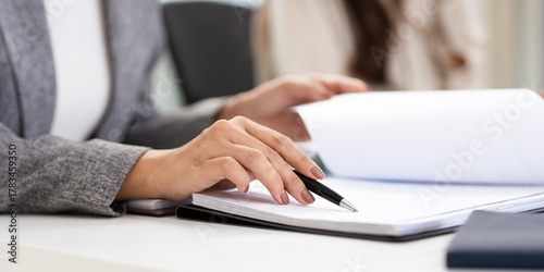 close up hands of Business partners working with analysis report and advisor showing plan, Two businesswoman working with Financial analysts reports and planning investment at office.