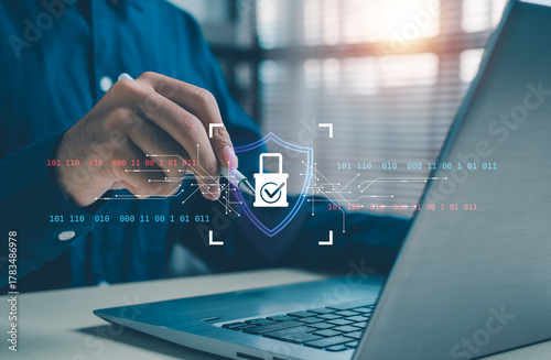 Cybersecurity concept showing a person using a laptop with a holographic lock and digital circuit overlay, symbolizing data protection, secure online connection, encryption, and privacy technology.