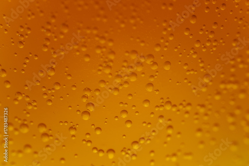 Cuadro en lienzo Extreme close-up of a yellow-orange carbonated liquid with rising bubbles creating a textured and bright background