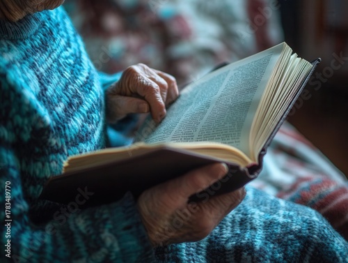 Elderly woman's hands gently flipping through the pages of a book while sitting in a cozy room filled with soft natural light