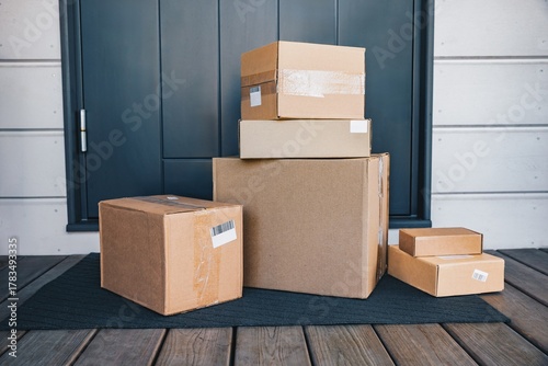Quadro su tela An Array of Brown Cardboard Boxes Stacked Neatly on a Doorstep, Showcasing Vario
