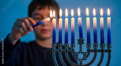 Young boy lighting candles on a menorah during hanukkah celebration