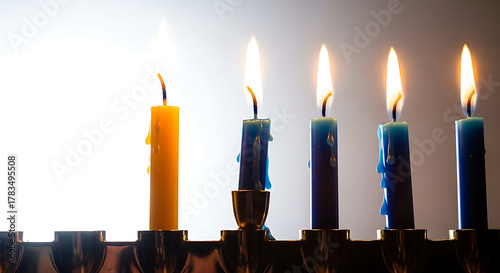 Close up of lit hanukkah candles on a menorah with bright light