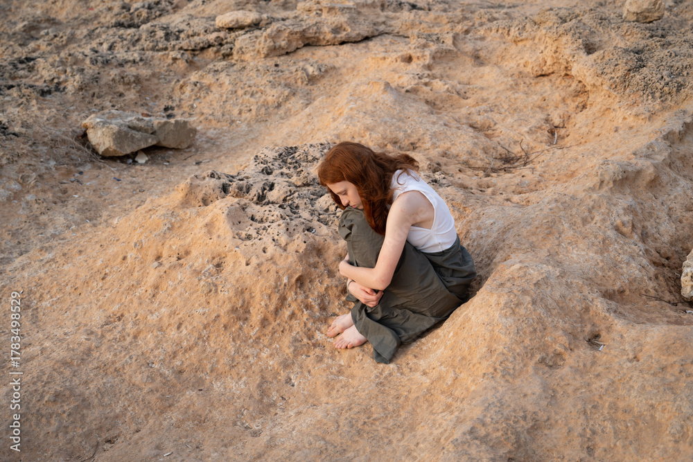 Naklejka premium red-haired young woman on the seashore in the evening