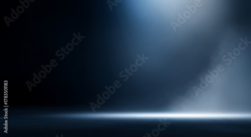 Dramatic blue spotlight illuminating a dark, empty stage with smoke and floor reflections, creating a cinematic atmosphere for product presentation