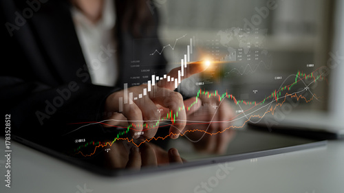 Canvastavla Professional analyzes financial graphs and indicators on a tablet in a modern office, showcasing technology impact on business strategy and growth insights