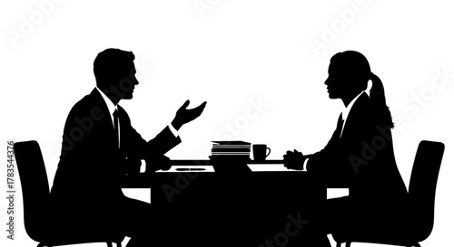 Silhouettes of a man gesturing and a woman listening during a business meeting at a desk with papers