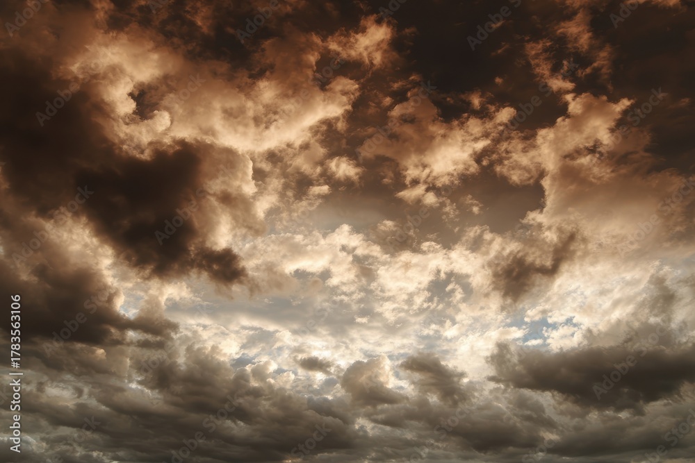Obraz premium Dramatic Cloudscape with Rich Shades and Textured Formations Underneath an Evolving Sky