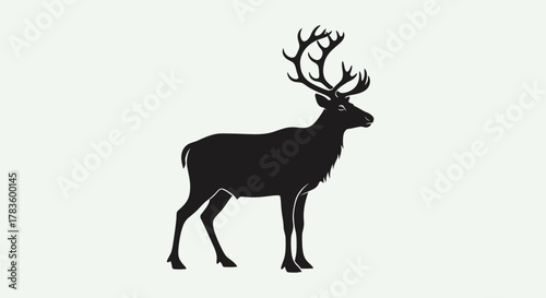 A black silhouette of a majestic reindeer with large antlers standing against a plain white background.