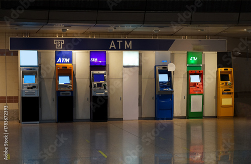 Various bank ATMs in different colors are installed at a gas station for customer convenience 