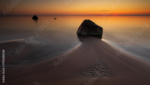 Fototapeta Naklejka Na Ścianę i Meble -  Sunset seascape with rock on sandy beach in Lahemaa National Park, Estonia.