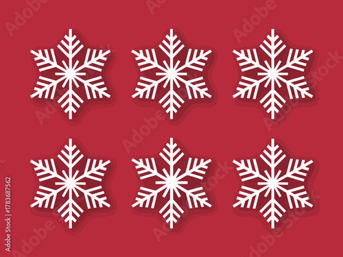 An artistic arrangement of intricate white snowflakes set against a vibrant red background, symbolizing winter, beauty, and the uniqueness of nature's creations.