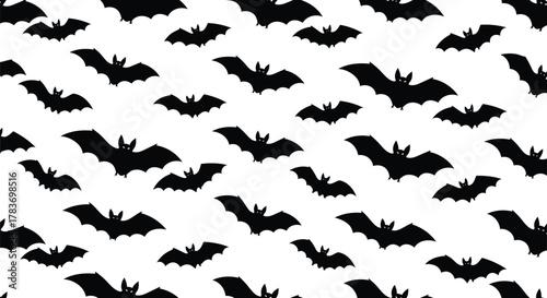 Spooky halloween seamless bat pattern: scattered flying black silhouette background.