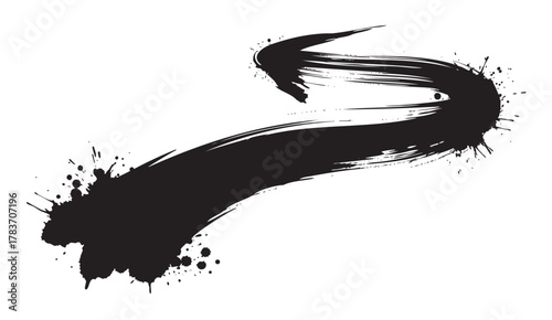 Abstract black ink brush stroke with splatters creating a dynamic curved path on a white background.
