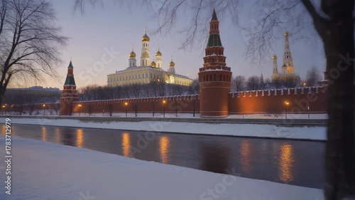 Moscow Kremlin Winter Twilight Riverbank Snowfall Golden Domes Illuminated Towers Historic Architecture Evening Lights Serene Landscape