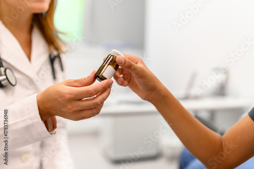 Foto Midsection of female pediatrician giving antibiotics to young boy in hospital du
