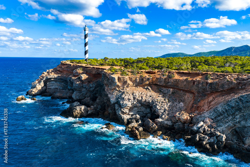 Aerial View of the Striped Moscarter Lighthouse (Far de sa Punta des Moscarter) on the Rugged Northern Cliffs of Ibiza, Spain