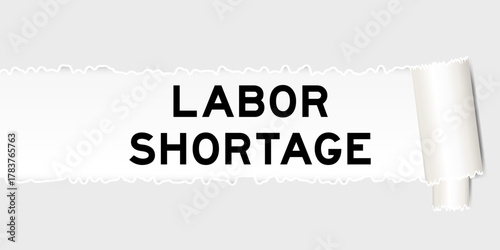 Ripped gray paper background that have word labor shortage under torn part