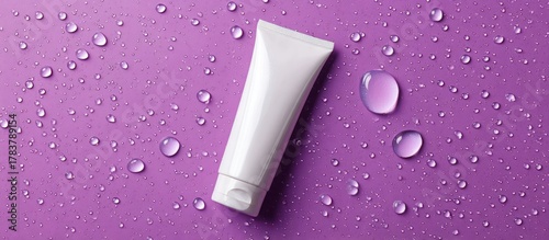 White tube with water drops on purple background