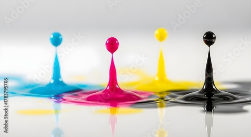 Cmyk ink droplets splashing and dripping in a studio setting