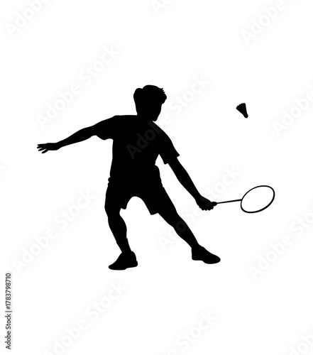 Silhouette of a male badminton player in action hitting a shuttlecock with a racket during a match