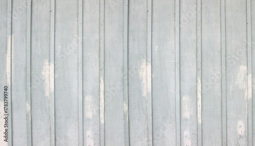 A soft pale blue painted wooden wall with vertical planks and weathered, peeling paint texture, creating a rustic and vintage background
