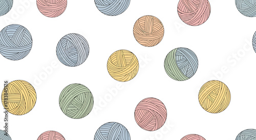 Colorful yarn balls scattered across a white background creating a playful pattern.