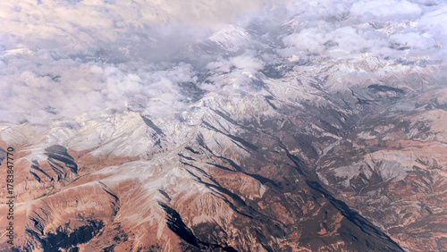 Above the peaks a clouds covers the sky, snow capped Alps rugged mountain peaks