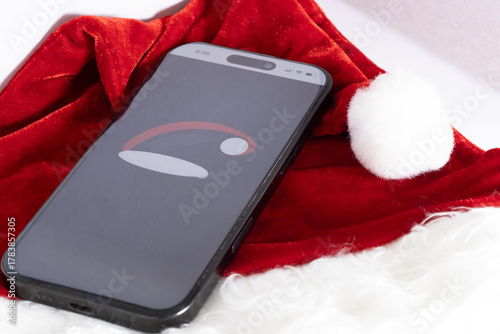 Real santa hat and a santa hat on the mobile phone christmas 25 celebration and holiday begins