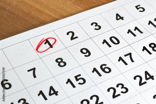 Number 1 marked in the calendar with red color circle to point important date on the wooden table