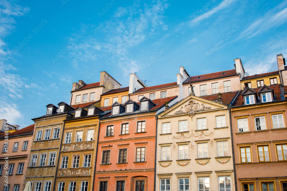 Obraz premium Old tiny historical houses facades and blue sunny sky in Warsaw old town square in Poland