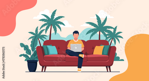A young man enjoys working remotely from a comfortable couch surrounded by tropical palm trees and vibrant foliage.