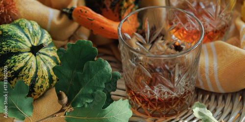 Fototapeta Whiskey glass with oak leaves and fall squash
