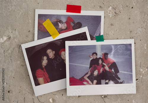 Three blank polaroids templates resting against a textured surface with colorful tape holding them in place