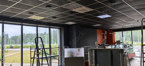 Canvas-taulu Construction progress inside a modern building with large windows and display ca