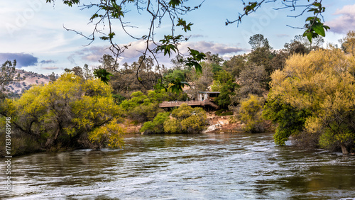 Serene river scene with autumn foliage rustic bridge. Tranquil landscape, golden hour light, nature beauty. Perfect for relaxation or travel themes.