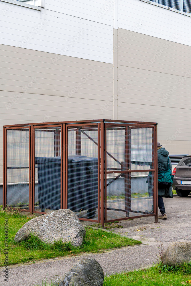 Naklejka premium Waste Bins in Caged Enclosure at Industrial Site