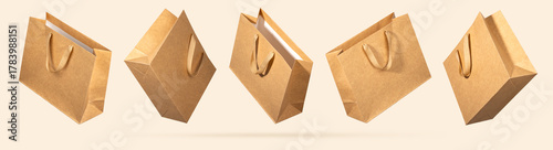 Five kraft paper shopping bags flying on beige background. Concept of eco-friendly packaging design for conscious retail, marketing visuals and sustainable shopping concepts. Mockup for branding