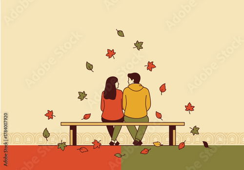Romantic autumn couple sitting on a bench amid falling leaves