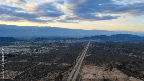 Aerial view of highway leading to mine with Chilecito city at sunrise, La Rioja, Argentina.
