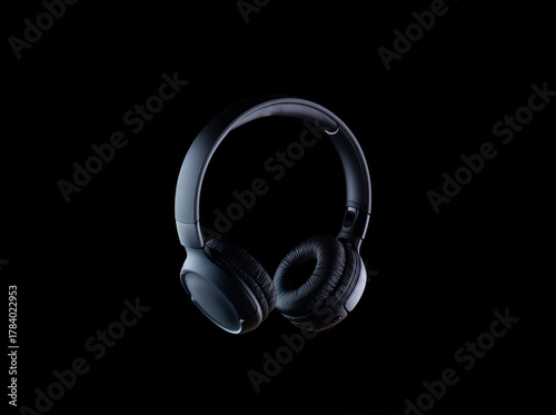 Headphones isolated on a black background. Black-on-black photography style.