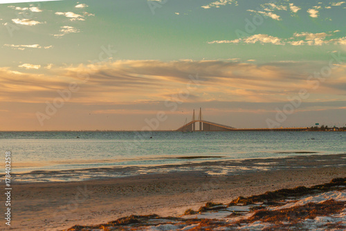 The Sunshine Skyway Bridge stretches gracefully across Tampa Bay at dawn, bathed in soft golden light as the new day begins