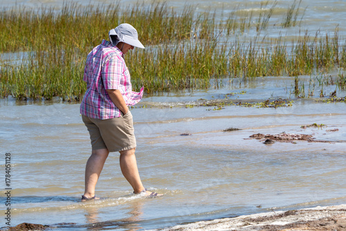 Plus Size overweight active woman walking in a marsh warm day