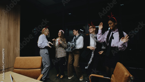 Fotografija Business women celebrating together at work before the Christmas holiday with fe