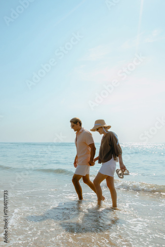 Young caucasian couple enjoying a beach walk under the sun