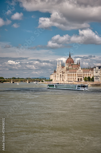 Budapest, Hungary – July 27, 2025: River cruise ship sailing along the Danube with the Hungarian Parliament Building in the background, showcasing scenic travel and architecture under a bright sky