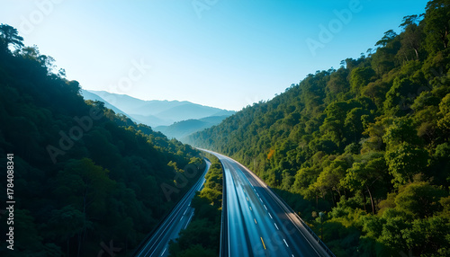 A winding highway stretches through a lush green mountainous landscape