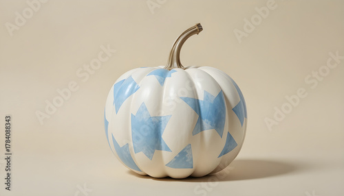 A painted pumpkin with geometric shapes and a soft neutral background
