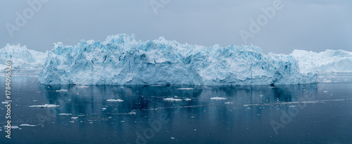 Giant icebergs floating in Ilulisat icefjord, Greenland. Massive icebergs, calved from the Sermeq Kujalleq Glacier, float through the Ilulissat Icefjord in western Greenland