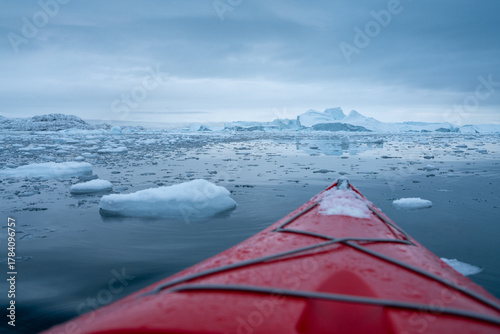 Giant icebergs floating in Ilulisat icefjord, Greenland. Massive icebergs, calved from the Sermeq Kujalleq Glacier, float through the Ilulissat Icefjord in western Greenland viewed from the kayak